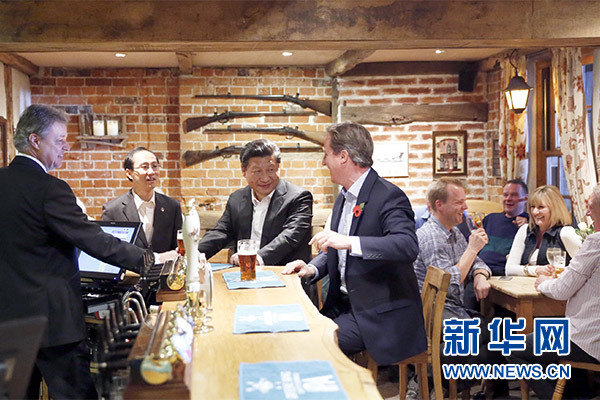 這是會晤結束后，習近平在卡梅倫陪同下乘車前往當地小鎮體驗酒吧文化。新華社記者 鞠鵬 攝